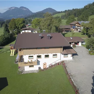 Ein schönes ehemaliges Bauernhaus in einer ruhigen ländlichen Umgebung. Umgeben von grünen Wiesen und Bergen im Hintergrund.