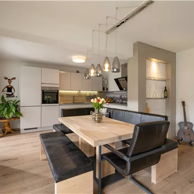 Modern kitchen with a dining area. Bright colors and cozy furnishings create an inviting atmosphere.