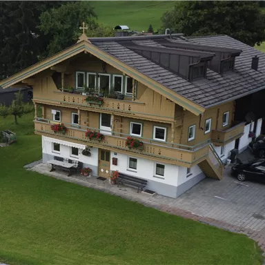 Ein traditionelles Bauernhaus aus dem Tiroler Unterland mit den typischen Balkonen und Blumenkästen.