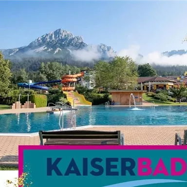 Ein schöner Pool mit Blick auf die Berge und viel Grün. Im Hintergrund sind Wasserrutschen und eine einladende Freizeitlandschaft zu sehen.