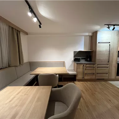 A modern kitchen with a wooden dining area. Bright furniture and an inviting atmosphere create coziness.