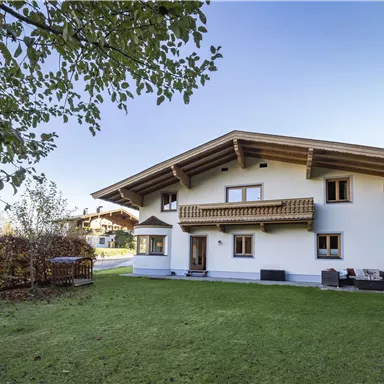 A modern house with a large garden and a beautiful terrace. Surrounded by trees and a peaceful environment.