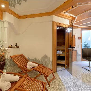 A relaxing wellness area with wooden loungers and a sauna. The atmosphere is cozy and inviting.
