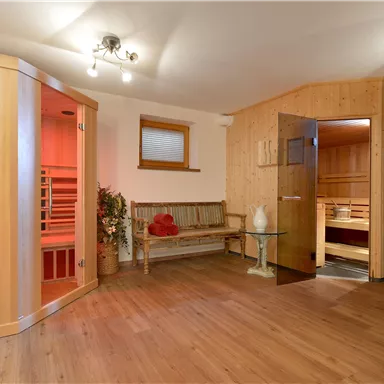 A cozy sauna area with wooden paneling and various sauna cabins. The atmosphere is inviting and relaxing.