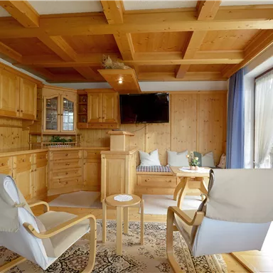 A cozy room with wooden furniture and large windows. The decor is modern and inviting, ideal for relaxation.
