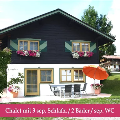 A charming chalet with colorful flowers and a sunny terrace. The house features three bedrooms and two bathrooms.