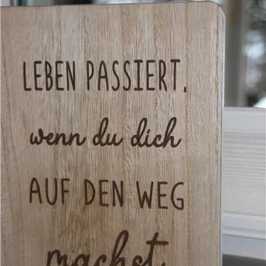 A wooden sign with an inspiring saying. The text encourages taking action and following your own path.