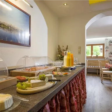 An inviting breakfast buffet with a variety of foods and fresh juices. The room is brightly and cozily designed.