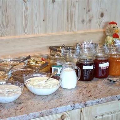 A breakfast buffet with various bowls. There is muesli, yogurt, jam, and Nutella.