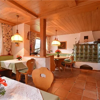 Ein gemütliches Restaurant mit Holzdekor und warmen Farben. Die Tische sind festlich gedeckt und mit Blumen dekoriert.