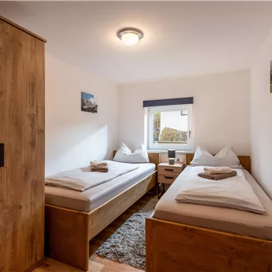 Ein gemütliches Zimmer mit zwei Einzelbetten und Holzinterieur. Die Betten können auch zusammengestellt und als Doppelbett genützt werden.