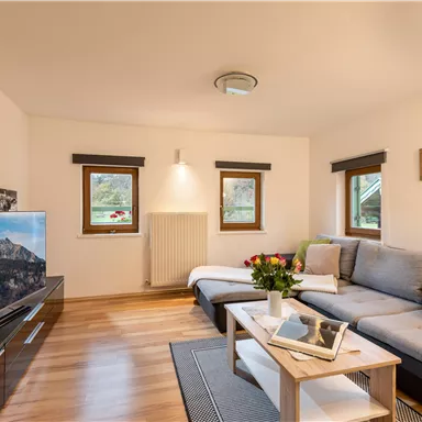 Ein gemütliches Wohnzimmer mit hellen Wänden und einem bequemen Sofa.