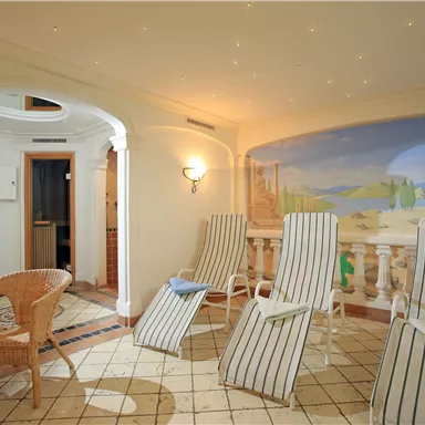 A relaxing wellness area with loungers and a beautiful mural. The room radiates tranquility and comfort.