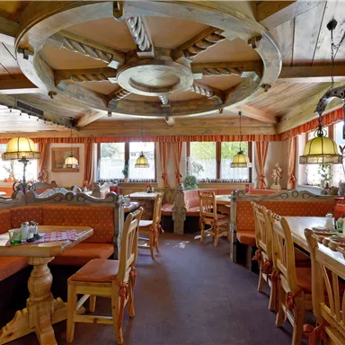 A cozy restaurant with wooden furniture and warm colors. Large windows provide plenty of light and an inviting atmosphere.