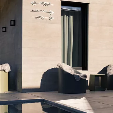 A modern outdoor area with a pool and comfortable seating. A wall with directional signs is visible.