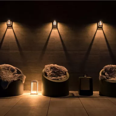 An elegant lounge with three cozy seating areas and soft lighting. The atmosphere is warm and inviting.