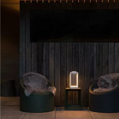 A stylish interior with two modern armchairs and cozy lighting. The wall is made of wood, which creates a warm atmosphere.