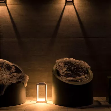 A cozy room with two round armchairs and a lit table. Soft light creates a relaxed atmosphere.