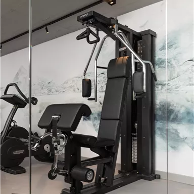 A modern gym with a power station and a training bench. The walls are decorated with an appealing background design.
