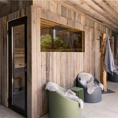 A modern wellness area with a wood sauna and stylish seating. The atmosphere is relaxing and inviting.