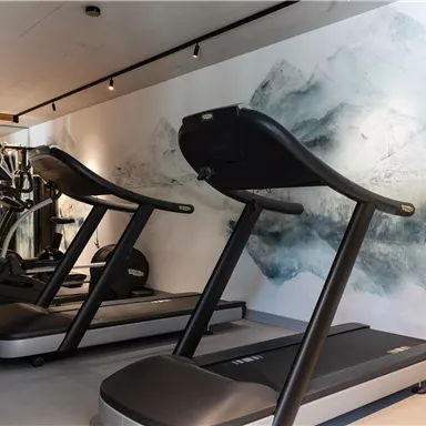 A modern gym with two treadmills and a decorative wall design. Bright and inviting atmosphere for training.