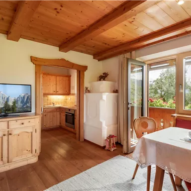 Eine gemütliche Wohnung mit Holzverkleidung und einem großen Fenster. Der Essbereich ist hell und einladend, mit Blick auf die Natur.
