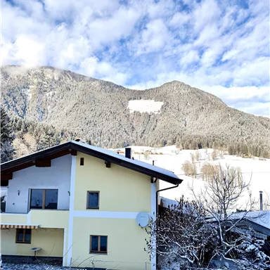 In diesem gelben Haus befinden sich alle 3 Appartements. Diese Landschaft können Sie im Winter in Söll erleben