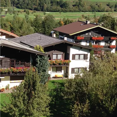 A picturesque village with beautiful houses and colorful flower boxes. Surrounded by green meadows and trees.