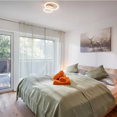A cozy bedroom with a large bed and soft green colors.
Large windows let in plenty of daylight and create a pleasant atmosphere.