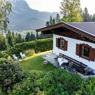 An idyllic holiday home in nature with a view of the mountains. In the garden, there are deck chairs and a table for relaxing moments outdoors.