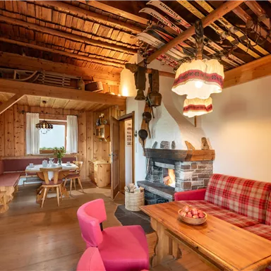 A cozy interior with wooden paneling and rustic furniture. The room has a fireplace and an inviting atmosphere.
