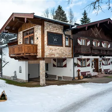 Ein wunderschönes Chalet im Winter, umgeben von Schnee. Die Architektur kombiniert traditionelle und moderne Elemente.
