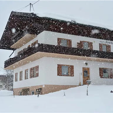 Ein schneebedecktes Haus in einer winterlichen Landschaft. Großer Schneefall und eine ruhige, friedliche Umgebung.