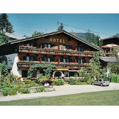 A traditional hotel with blooming balcony flowers.
Surrounded by a picturesque mountain landscape.