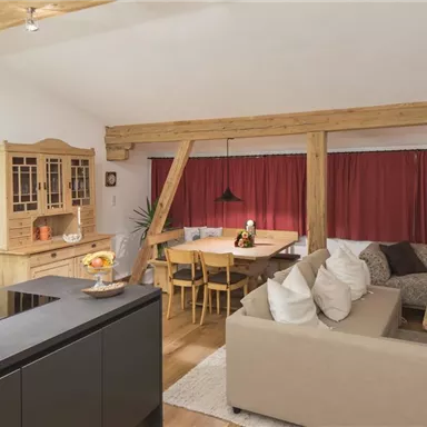 A modern kitchen with wood details and a cozy dining area. The atmosphere is bright and inviting.