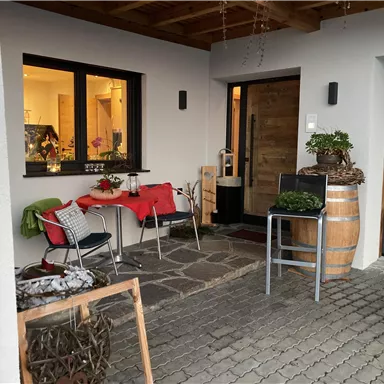An inviting entrance area with a table and chairs. The atmosphere is cozy and friendly, perfect for relaxed moments outdoors.