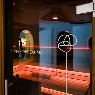 An entrance to a Finnish sauna with modern lighting. The atmosphere is inviting and relaxing.