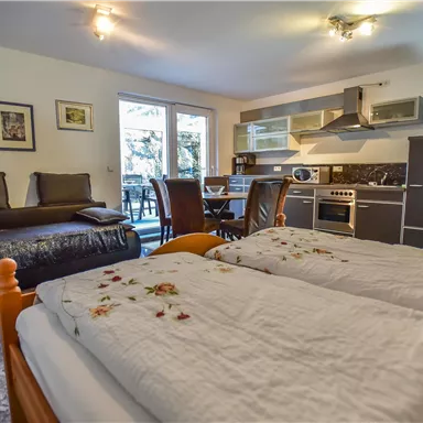 A cozy room with two beds and a modern kitchenette.
Large windows provide plenty of natural light and a view of the outdoors.