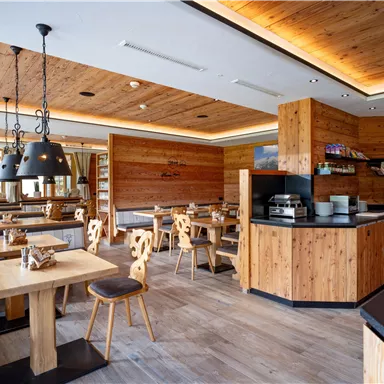 Ein gemütliches Restaurant mit Holzmöbeln und warmem Licht. Die Einrichtung ist modern und einladend.