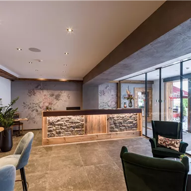 A modern reception area with wood and stone elements.  
Large windows ensure plenty of light and a pleasant atmosphere.