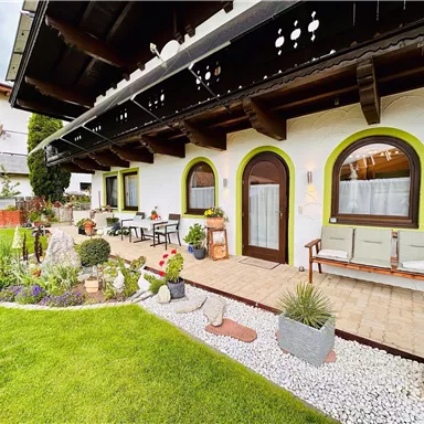A cozy house with a well-maintained garden. The outdoor area is equipped with colorful flowers and seating.