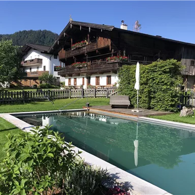 A cozy house with a balcony and garden. The swimming pool adds to the relaxing atmosphere outdoors.