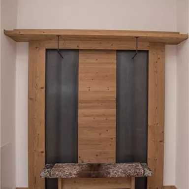 Eine moderne Holz-Garderobe mit einem bequemen Sitzbereich aus Stein. Die Kombination aus Holz und Metall verleiht dem Raum einen eleganten Look.