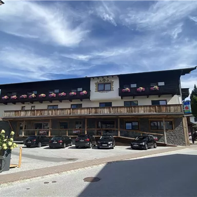 A cozy hotel with blooming balcony boxes. Parking spaces are available directly in front of the building.
