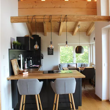 A modern kitchen with wood decor and high bar stools.
Large windows provide plenty of light and an inviting space.