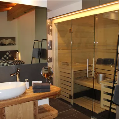 A modern bathroom with a sauna and an elegant shower. The decor combines wood and glass for a cozy atmosphere.