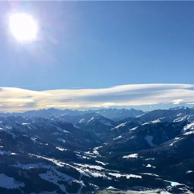 Eine beeindruckende Berglandschaft unter einem strahlend blauen Himmel. Die schneebedeckten Gipfel reflektieren das Sonnenlicht und schaffen eine malerische Aussicht.