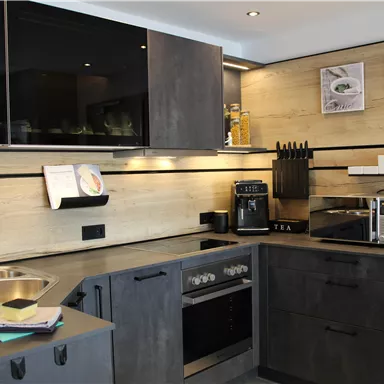A modern kitchen with dark cabinets and light walls.