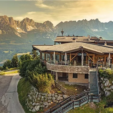 A picturesque mountain cabin with modern amenities and a beautiful view of the mountains. The surroundings are green and inviting, ideal for a relaxing stay in nature.