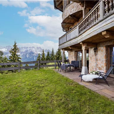 A cozy balcony with a view of the mountains. The surroundings are green and the atmosphere is relaxed.